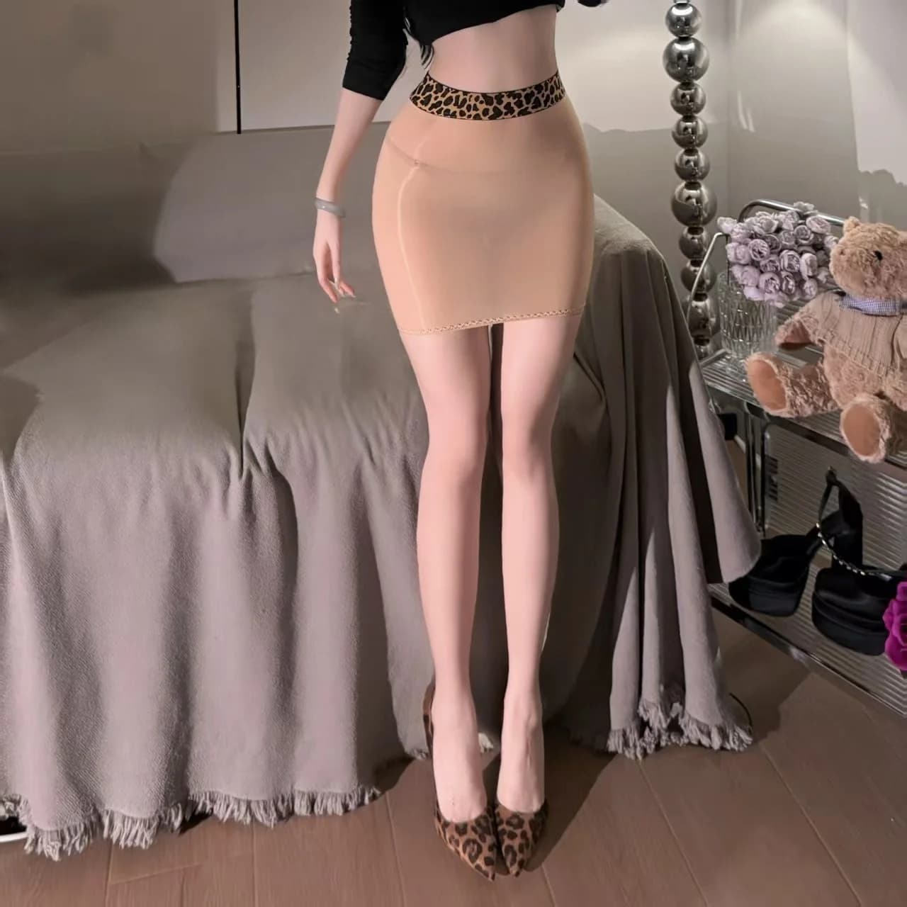 Jupe courte moulante et sexy en tissu soyeux imprimé léopard, effet brillant, avec détails en cuir d